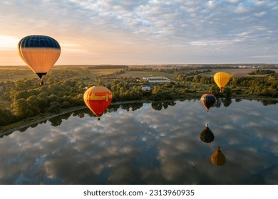 Colorful hot air balloons over lake at sunrise
