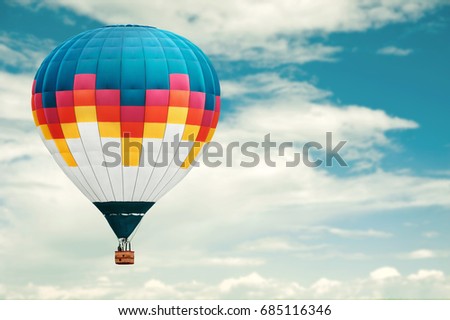 Colorful hot-air balloon against blue cloudy sky