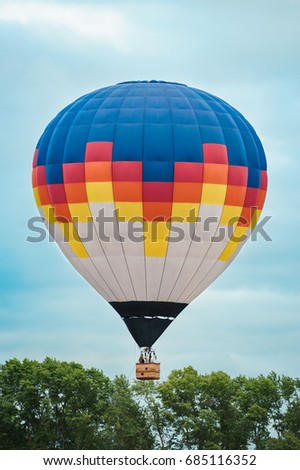 Colorful hot-air balloons flying over the trees