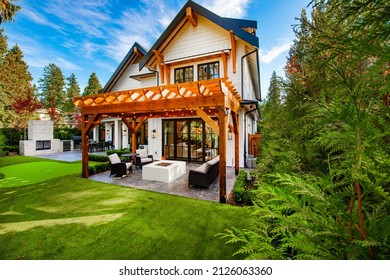 Colorful House With Peak Roof Large Windows In Autumn Fall Sunny Blue Sky And Vivid Landscaping