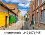 Colorful houses of Amiens historical city centre Saint-Leu quarter. Narrow cozy street between brick buildings old town in France, Picardy, Somme department, Hauts-de-France Region, Northern France