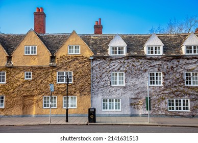 Colorful houses are covered in plants on a street in Oxford, UK - Shutterstock ID 2141631513