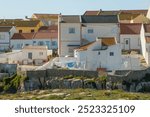 Colorful houses of the Peniche fishing village in Portugal. Traditional portuguese scebe with old houses and sun drying laundry.