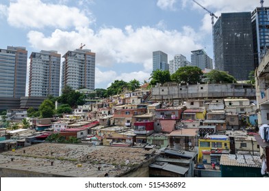 Colorful houses of the poor inhabitants of Luanda, Angola. These ghettos resemble Brazilian favelas. In the background the high rise buildings of the rich build a stark contrast.