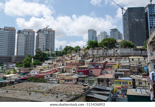 アンゴラのルアンダの貧しい住民のカラフルな家々 これらのゲトスは ブラジルのファヴェラに似ています その背景には 高層ビル群の豊かさが著しいコントラストを示している の写真素材 今すぐ編集