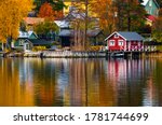 Colorful houses and trees reflecting in the water surface. Autumn in Rauma, Finland. 