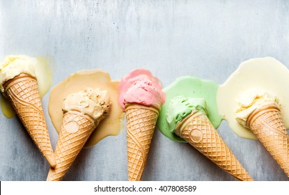 Colorful ice cream cones of different flavors. Melting scoops. Top view, copy space, steel metal background - Powered by Shutterstock