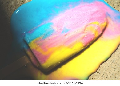 Colorful ice cream melted on the tile floor with light and shadow