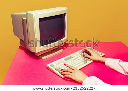 Colorful image of vintage computer monitor and keyboard on bright pink tablecloth over yellow background. Typing information. Concept of retro pop art, vintage things, mix old and modernity