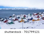 Colorful inuit houses among rocks and snow at the fjord in a suburb of arctic capital Nuuk, Greenland
