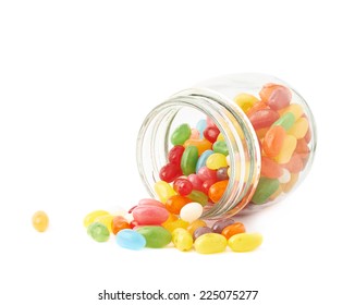 Colorful Jelly Bean Candy Sweets Spilled Out Of A Glass Jar, Composition Isolated Over The White Background