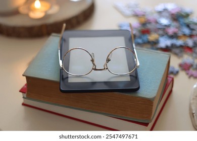 Colorful jigsaw puzzle pieces, books, tablet, glasses, cookies, berries, cup of tea or coffee, glass of juice and lit candles on the table. Hygge in pastel colors. Selective focus. - Powered by Shutterstock