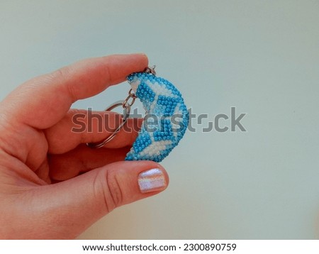 Colorful keychain lies on a woman's palm. Bead colorful key chain in hand