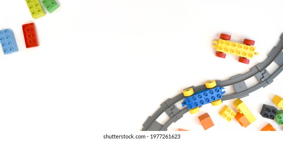 Colorful Kids Toys Flat Lay With Toy Train, Railway, Plastic And Wooden Blocks On White Background. Children Border Educational For Preschool , Playground And Kindergarden. Top View. Copyspace.