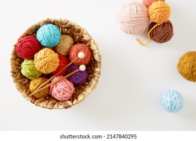 Colorful knitting yarn in a basket on white background. Needlework and hobby. DIY concept.