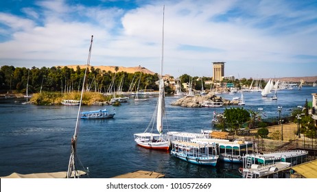 Colorful landscape with boats on a busy river. Nile river in Aswan with tourist boats, feluccas and yachts