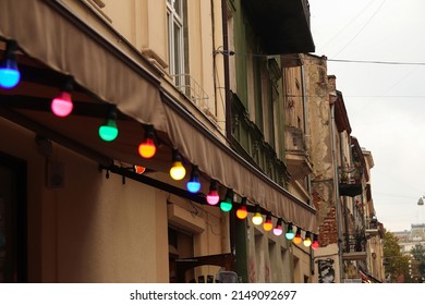 Colorful Light Bulbs. Classic Architecture Details. Old Facade With Light Bulb. Decorative External Lighting. Classic Architecture. Exterior Walls Of Old Building. Ukraine, Lviv. Cloudy Summer.