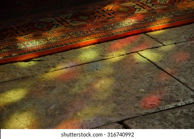 Colorful Light Spots On The The Floor And Carpet In Church. Sunlight Filtered Through The Stained Glass Window. A Game Of Light And Shadow.