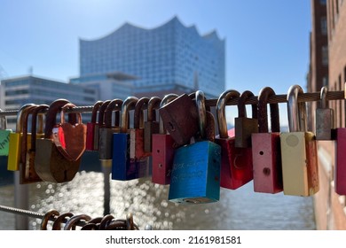 Colorful Love Locks hanging on a bridge in the Speicherstadt and port of Hamburg. Concert Hall Elbphilharmonie out of focus in background. Lovers Ritual.