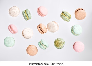 Colorful macarons cake, top view flat lay, fly falling sweet macaroon on color white isolated background. Minimal concepts falling macaroons pattern above, food natural background