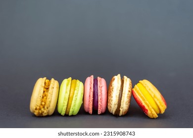 Colorful macarons cakes. Small French cakes on the black background. - Powered by Shutterstock