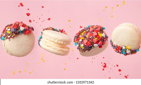 Colorful Macarons Cookies In Motion. French Cakes. Sweet And Colorful French Macaroons Fall Or Fly In Motion. With Slices On A Pink Background, And Flying Particles