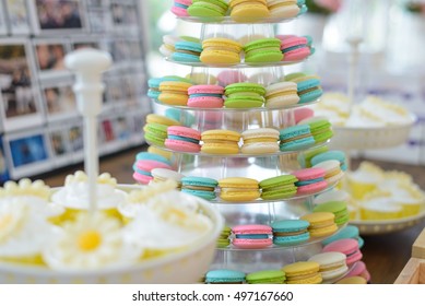 Colorful macarons on pyramid-shaped plastic stand at party