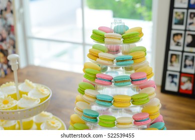 Colorful macarons on pyramid-shaped plastic stand at wedding party