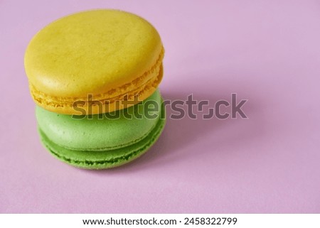 Colorful macaroons on pink background, close-up.