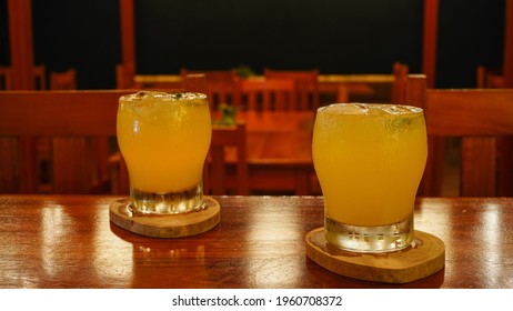 Colorful Margarita Coctail Served In A Glass On The Wooden Board, Drink Served On A Bar Counter In Empty Bar, No People In The Bar With Refreshing Drink Melting On The Bar Counter. 