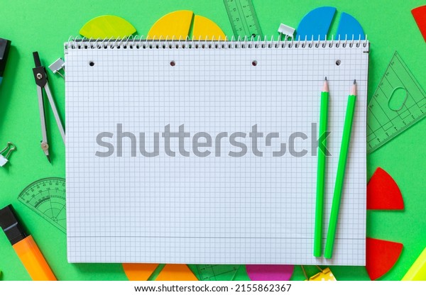 Colorful math fractions, rulers, open notepad on\
a green background. Interesting, fun math for kids. Education, back\
to school concept