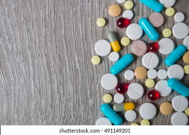 A Lot Of Colorful Medication And Pills From Above On Grey Wooden Background. Copy Space. Top View, Frame. Painkillers, Tablets, Generic Pills, Drugs. 