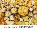 Colorful mix of salty snacks for beer varieties: chips and pretzels, onion rings and crackers. Non-healthy junk food background
