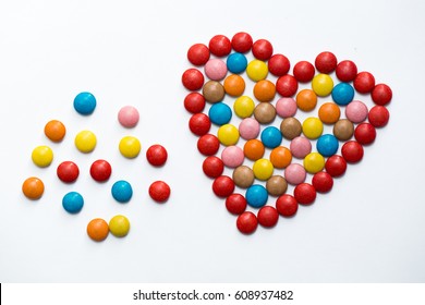 Colorful m&m button chocolate candies in the love shape on white background. - Powered by Shutterstock