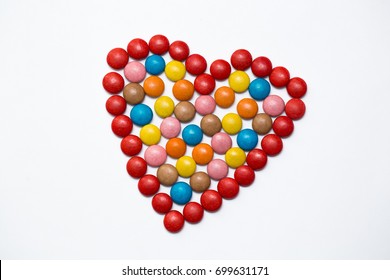 Colorful m&m button chocolate candies in the love shape on white background. - Powered by Shutterstock