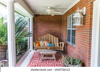 Colorful And Modern Bohemian Boho Outdoor Front Porch Decoration With Seating And A Plant. The House Is Red Brick And Traditional.