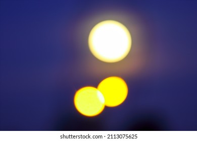 Colorful moon and two lanterns in the night sky, soft focus, bokeh