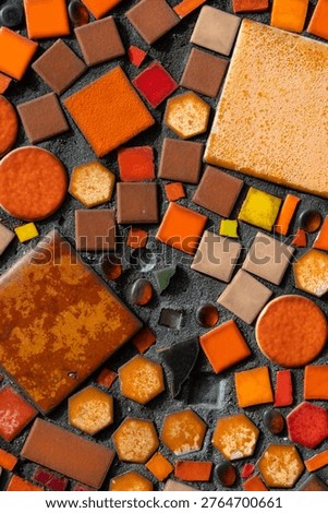Colorful mosaic random pattern on dark cement mortar, featuring ceramic tiles and glass pieces