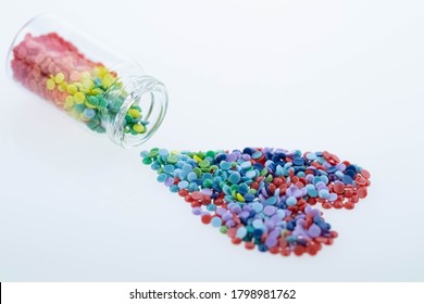 Colorful Multicolor Beads Or Tablets Are Poured Into A Glass Bottle. A Rainbow In A Bottle. Magic Pills. Heart