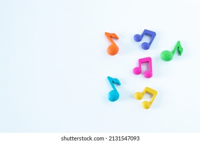 Colorful music notes shape isolated on white background. Copy space. Top view. The concept of happiness, joy, singing, and playing at school. A closeup.