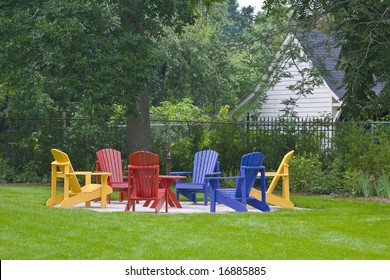 Colorful muskoka chairs in a backyard