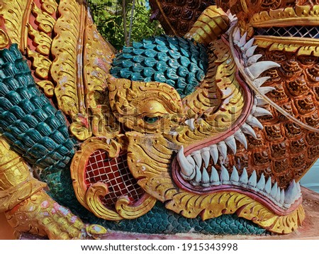 Colorful mythical creatures on temple's staircase rail 