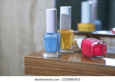 Colorful nail polishes on a wooden table in front of the mirror, close up, macro photography - Powered by Shutterstock