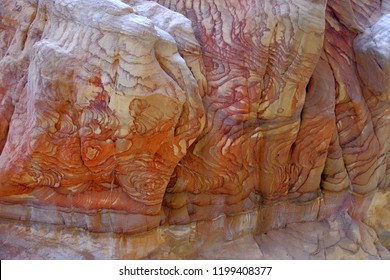 Colorful nature pattern painted on the rock wall in narrow canyon in Jordan. Pattern on the rocks, created by nature.