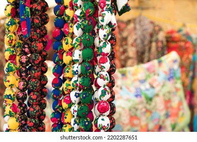 Colorful necklaces in folk or ethnic chic style as background with copy space. Handmade fabric necklaces at souvenir stall or street market