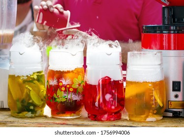 Colorful Nonalcoholic Fruit Drinks With Dry Ice Smoke Effect, Served On Bar Counter. Summer Chill Drink.