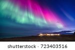 colorful northern lights in a iceland landscape with cottage mountain and sea