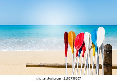 Colorful oars over fine sandy beach with clear blue sky background, tropical island beach in south of Thailand, water sport equipment on the beach