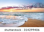 Colorful ocean beach sunrise with deep blue sky and sun rays.