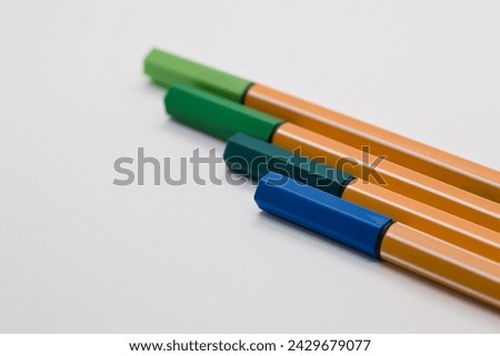 Colorful office fineliners lying next to each other on a piece of paper